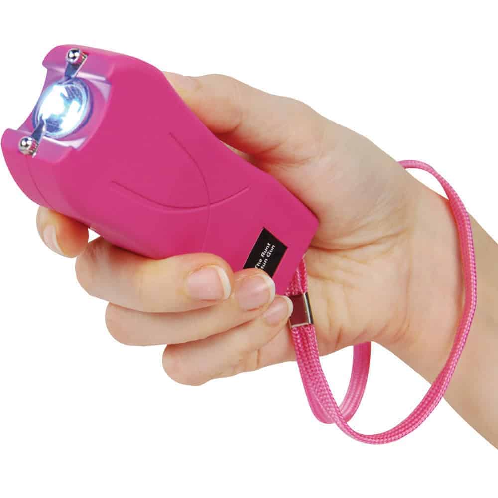 Pink Runt Rechargeable Stun Gun With Flashlight And Wrist Strap Disable Pin Shown in Hand