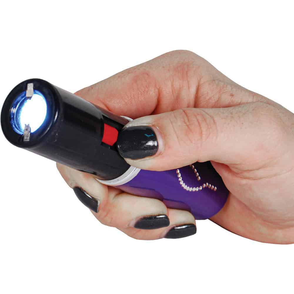 Purple 25 Million Volt Lipstick Stun Gun Rechargeable With Flashlight Shown in Hand