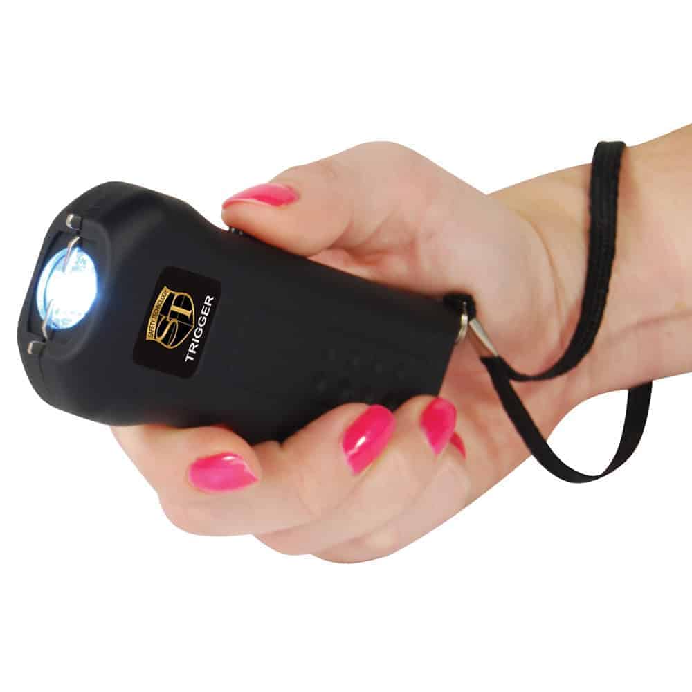 Black 75 Million Volt Trigger Stun Gun Flashlight with Disable Pin Shown in Hand