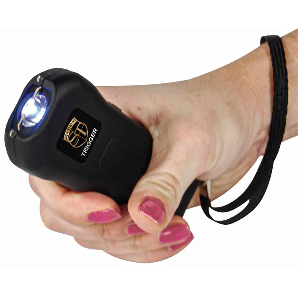 Black 75 Million Volt Trigger Stun Gun Flashlight with Disable Pin Shown in Hand