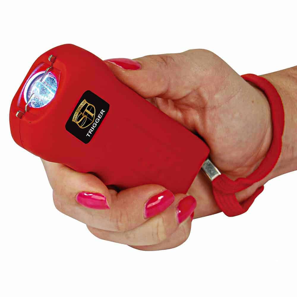 Red 75 Million Volt Trigger Stun Gun Flashlight with Disable Pin Shown in Hand